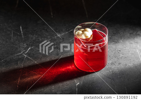 Red cocktail with ice and chocolate in spotlight Red cocktail with ice and chocolate in spotlight 130891192