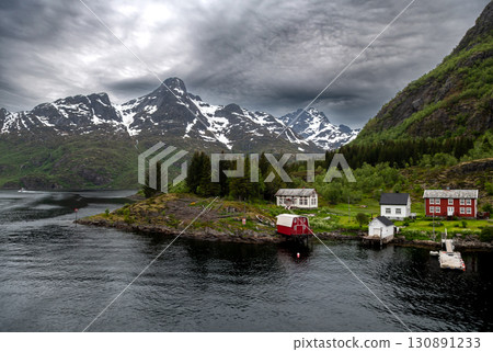 Coastal Landscape With Small Village And Snowy Mountains Near Trollfjord At The Lofoten In Norway Coastal Landscape With Small Village And Snowy Mountains Near Trollfjord At The Lofoten In Norway 130891233