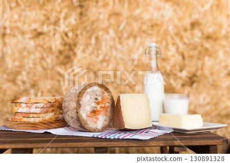 whole head of ripe country cheese and slices and milk in hayloft whole head of ripe country cheese and slices and milk in hayloft 130891328