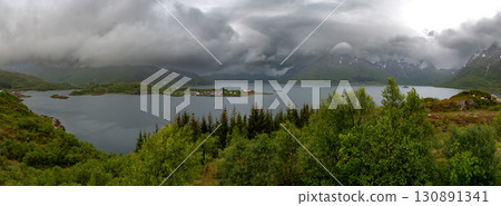Rural Landscape With Remote Village, Calm Fjord And Foggy Mountains On Lofoten Islands In Norway Rural Landscape With Remote Village, Calm Fjord And Foggy Mountains On Lofoten Islands In Norway 130891341