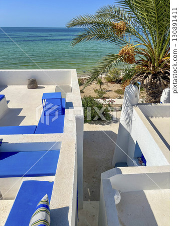 Beautiful view from the white rooftop in Djerba, Tunisia overlooking the sea and palm trees on a Beautiful view from the white rooftop in Djerba, Tunisia overlooking the sea and palm trees on a 130891411