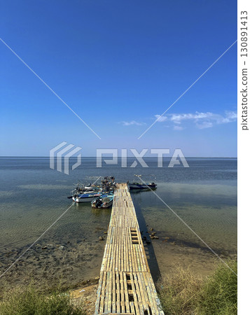 Fishing boats on the serene shores of Djerba, Tunisia under a clear blue sky during a calm day at Fishing boats on the serene shores of Djerba, Tunisia under a clear blue sky during a calm day at 130891413