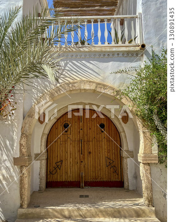 Beautifully crafted wooden door in Djerba Tunisia, showcasing traditional architecture and intricate Beautifully crafted wooden door in Djerba Tunisia, showcasing traditional architecture and intricate 130891435