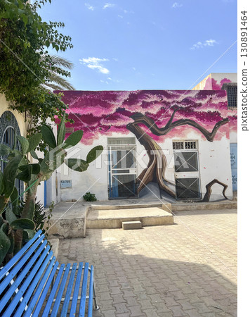 Exploring vibrant street art in Djerba, Tunisia, showcasing a stunning pink tree mural against a Exploring vibrant street art in Djerba, Tunisia, showcasing a stunning pink tree mural against a 130891464
