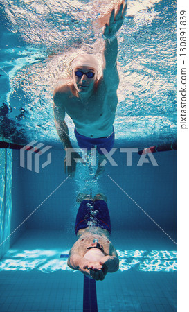 Collage with swimmers in dramatic underwater scene, moving in opposition with explosive energy. 130891839