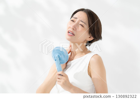 A woman who cools down with a handy fan 130892322