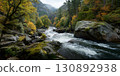 Natural Beauty And Tranquility: A Scenic Wide-Angle View Of A Forest River With Boulders And Lush Greenery Under A Cloudy Sky. 130892938