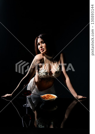 Spaghetti meal with a stylish woman in a studio setting at night 130893144