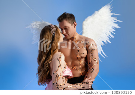 Romantic moment between angel couple with wings and nature details Romantic moment between angel couple with wings and nature details 130893150
