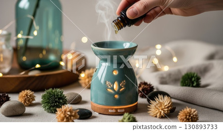 Hand Adding Essential Oil to Boho Diffuser 130893733
