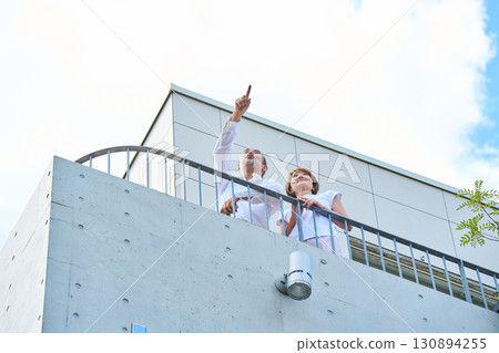 A wealthy middle-aged couple standing on the balcony 130894255