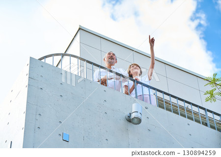 A wealthy middle-aged couple standing on the balcony 130894259