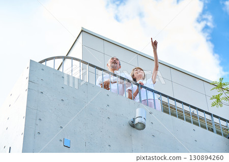 A wealthy middle-aged couple standing on the balcony 130894260