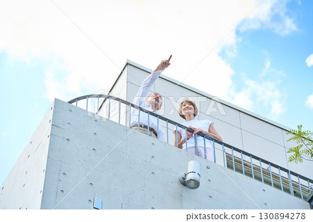 A wealthy middle-aged couple standing on the balcony 130894278