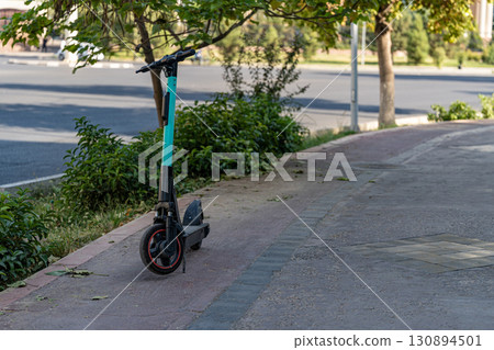 Electric scooter parked on sidewalk 130894501