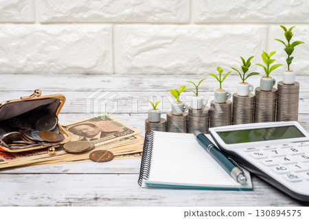Image of increasing savings with money, banknotes, memo pad and calculator 130894575