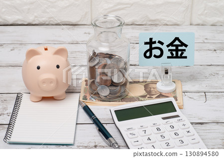 存錢筒、一罐硬幣、一個計算器和一本帶錢的筆記本的圖像 存錢筒、一罐硬幣、一個計算器和一本帶錢的筆記本的圖像 130894580