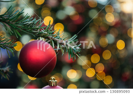 Christmas tree with red ball and lights garland. Xmas card. Close up. Winter. Outdoors. Christmas tree with red ball and lights garland. Xmas card. Close up. Winter. Outdoors. 130895093