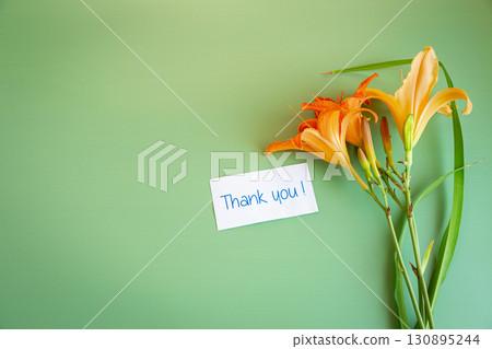 Bouquet of lilies with congratulations on a green background for Mother's Day 130895244