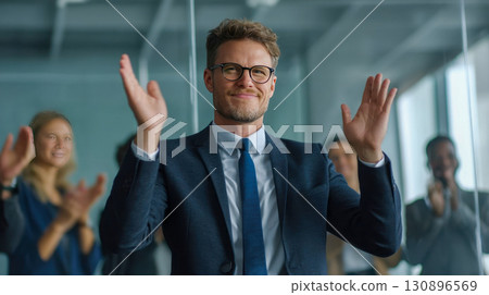 Successful businessman in business suit applauding with colleagues in office, corporate leadership and teamwork concept 130896569