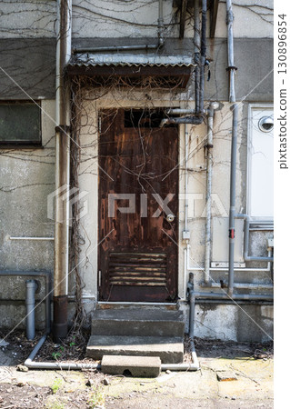 Rusty and ivy-covered door, door of an abandoned house Rusty and ivy-covered door, door of an abandoned house 130896854