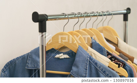 Upcycled denim fashion hanging on a rack at a second-hand store for stylish shoppers 130897016
