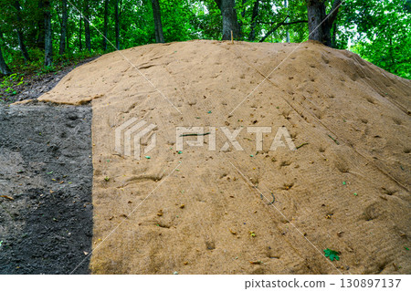 Soil erosion protection matting installed on slope for stabilization and ecological restoration Soil erosion protection matting installed on slope for stabilization and ecological restoration 130897137
