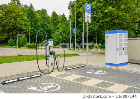 Electric vehicle charging station with parking spaces and power cabinet in urban setting 130897144