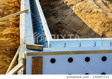 ICF foundation wall with visible rebar reinforcement during construction at modern building site 130897151