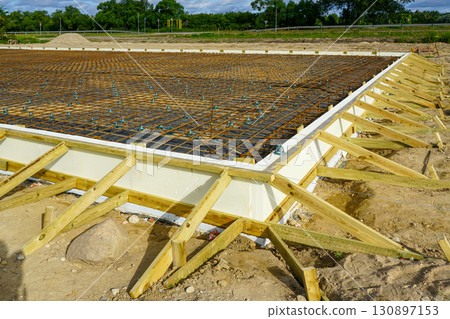 Thermal insulated concrete foundation with rebar reinforcement and wooden formwork at site Thermal insulated concrete foundation with rebar reinforcement and wooden formwork at site 130897153
