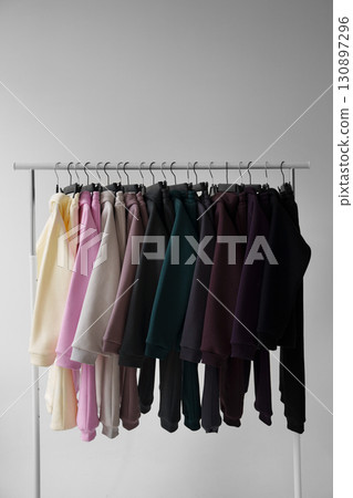 Colorful hoodies on hangers in a showroom. Colorful hoodies on hangers in a showroom. 130897296