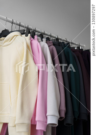 Colorful hoodies on hangers in a showroom. 130897297