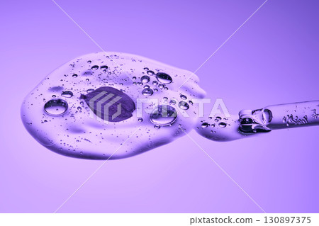A pipette with cosmetic serum and lilac petals. 130897375