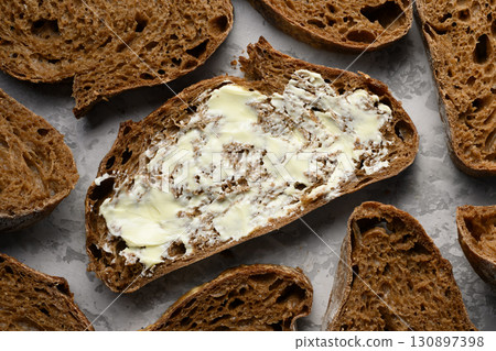 Artisan sliced rye sourdough bread with butter top view Artisan sliced rye sourdough bread with butter top view 130897398