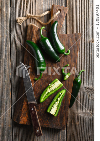 Black jalapeno with knife on rustic wooden cutting board Black jalapeno with knife on rustic wooden cutting board 130897401