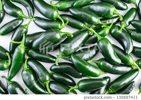 Heap of green mexican jalapeno hot peppers close up Heap of green mexican jalapeno hot peppers close up 130897411