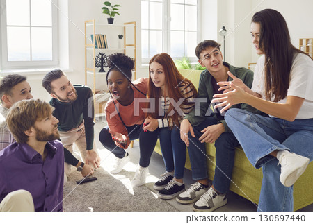 Team of friends sitting at home on sofa and talking with each other enjoying meeting. 130897440