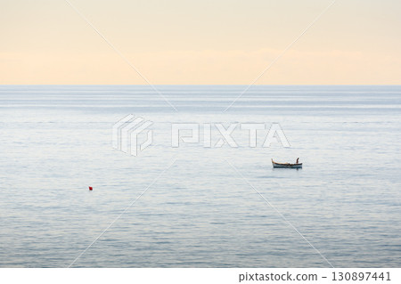Small lonely fishing boat in calm water of Mediterranean sea 130897441