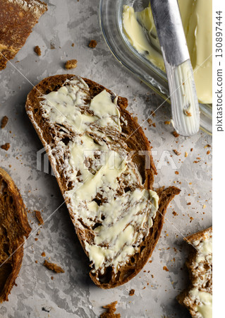 Top view of sliced rye sourdough bread with butter and knife close up Top view of sliced rye sourdough bread with butter and knife close up 130897444