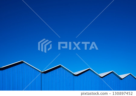 Wooden changing cabins against a clear blue sky 130897452