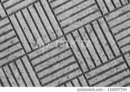 Textured concrete surface with diagonal grooves and patterns in a monochrome setting 130897704