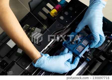 A technician is checking the printer's print head. 130897718