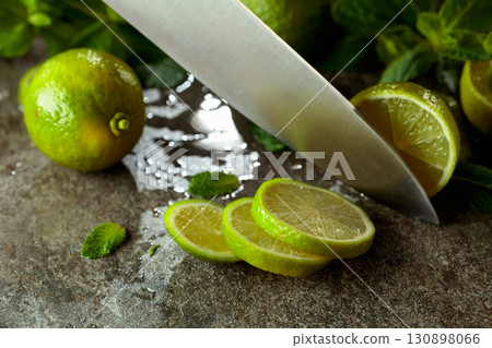 Knife, slices of lime and sprigs of fresh mint. Knife, slices of lime and sprigs of fresh mint. 130898066