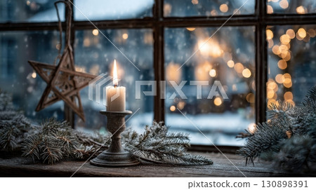 Burning candle in an antique candlestick sits on a snowy windowsil 130898391