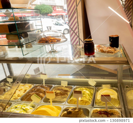 Display case with assorted artisanal ice cream in ice cream parlour 130898971