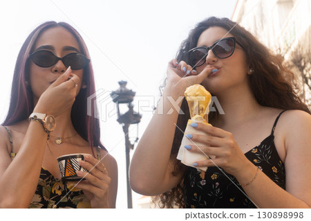 Friends Enjoying Ice Cream on the Street Friends Enjoying Ice Cream on the Street 130898998