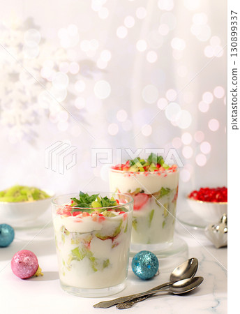 Kiwi and pomegranate parfait on a bright festive table, an idea for decorating food and decorating New Year's dishes. Christmas and New Year's dishes. Banner for the screen , template for creativity. 130899337