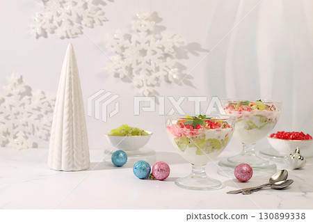 Kiwi and pomegranate parfait on a bright festive table, an idea for decorating food and decorating New Year's dishes. Christmas and New Year's dishes. Banner for the screen , template for creativity. 130899338