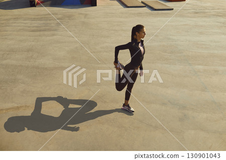 Sporty young woman doing fitness exercises during outdoor workout on city streets Sporty young woman doing fitness exercises during outdoor workout on city streets 130901043