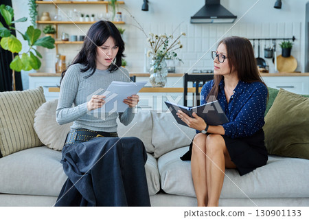 Female social worker working at home with young woman Female social worker working at home with young woman 130901133